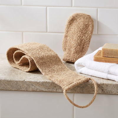 Jute scrub strap and mitt on bathroom shelf with towel