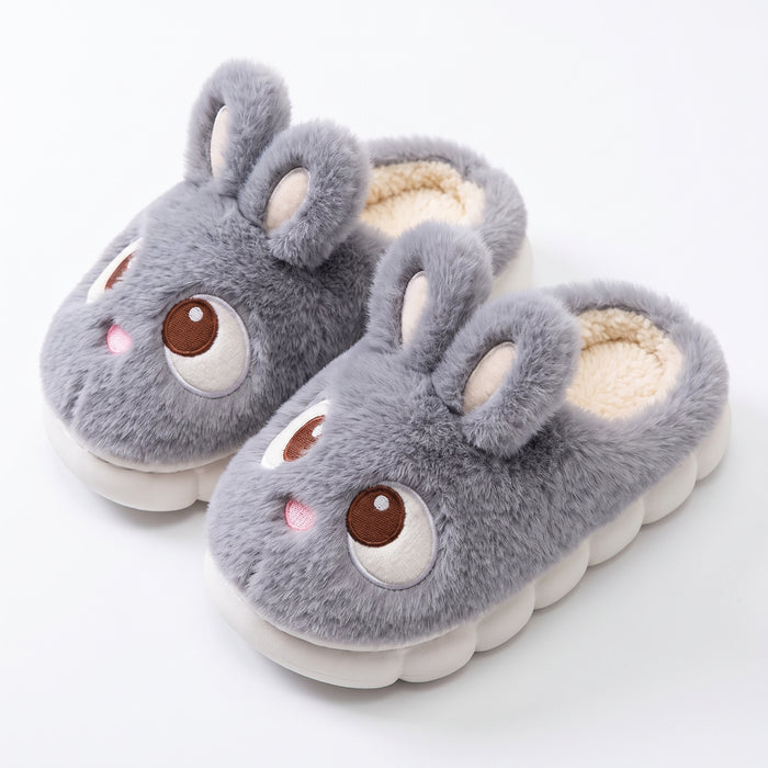 Gray plush bunny slippers with embroidered eyes on white background