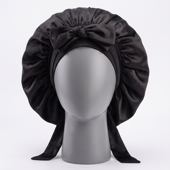 Black satin sleep bonnet on display form, front view