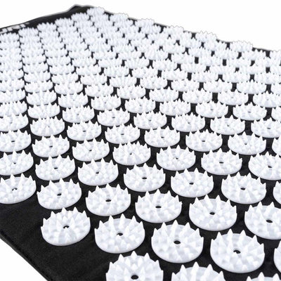 Close-up of white acupressure spike discs on mat