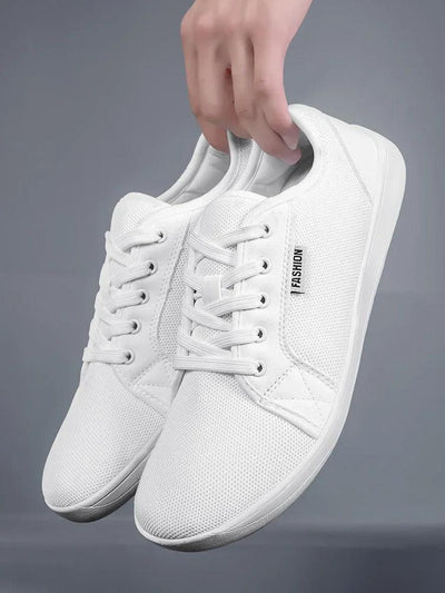 White barefoot sneaker pair held in hand