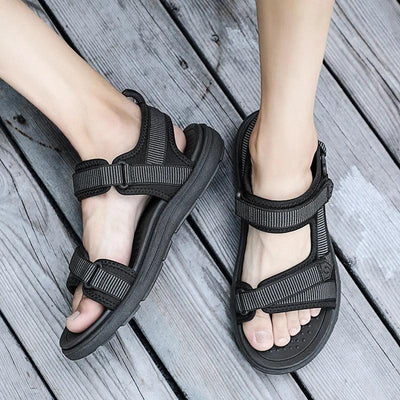 Black shock-absorbing sandals worn on wooden deck