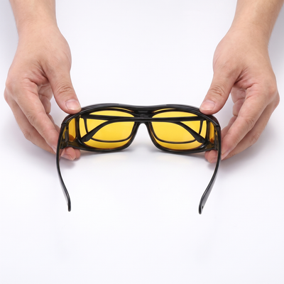 Hands holding night vision glasses showing the large interior space that fits over regular glasses