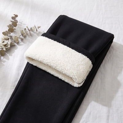 Black thermal leggings laid flat with the waistband folded to show the white fleece lining